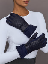 Model wearing quilted leather ski gloves in navy, front view with both hands visible.