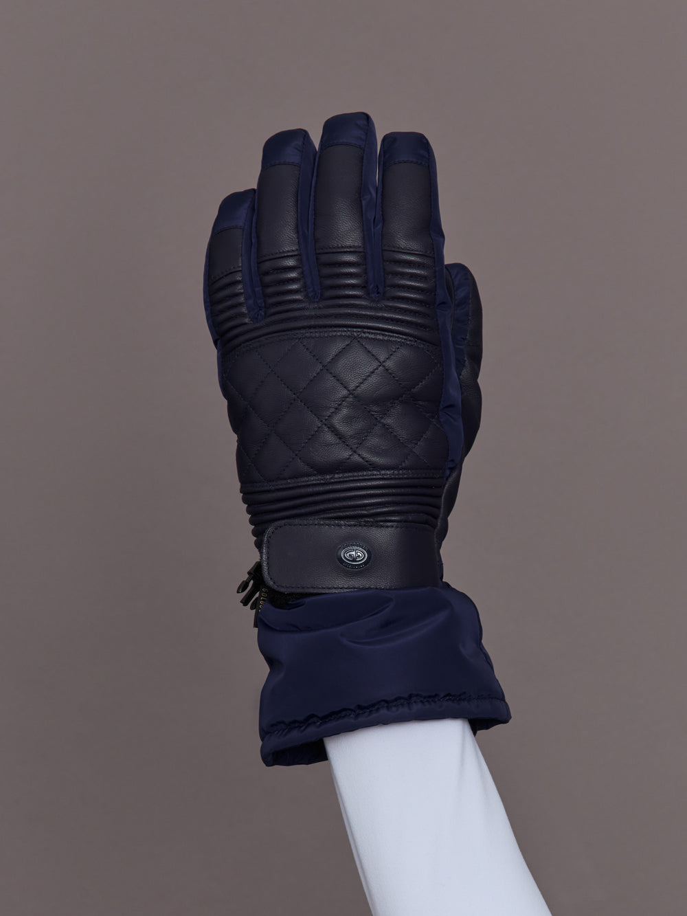 Close-up of quilted leather navy ski glove, top view.