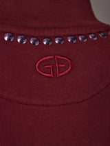 Close-up of tonal embroidered logo and stud neckline detail on Frenzy Crew Neck Fringe Sweatshirt in Vino Rosso.