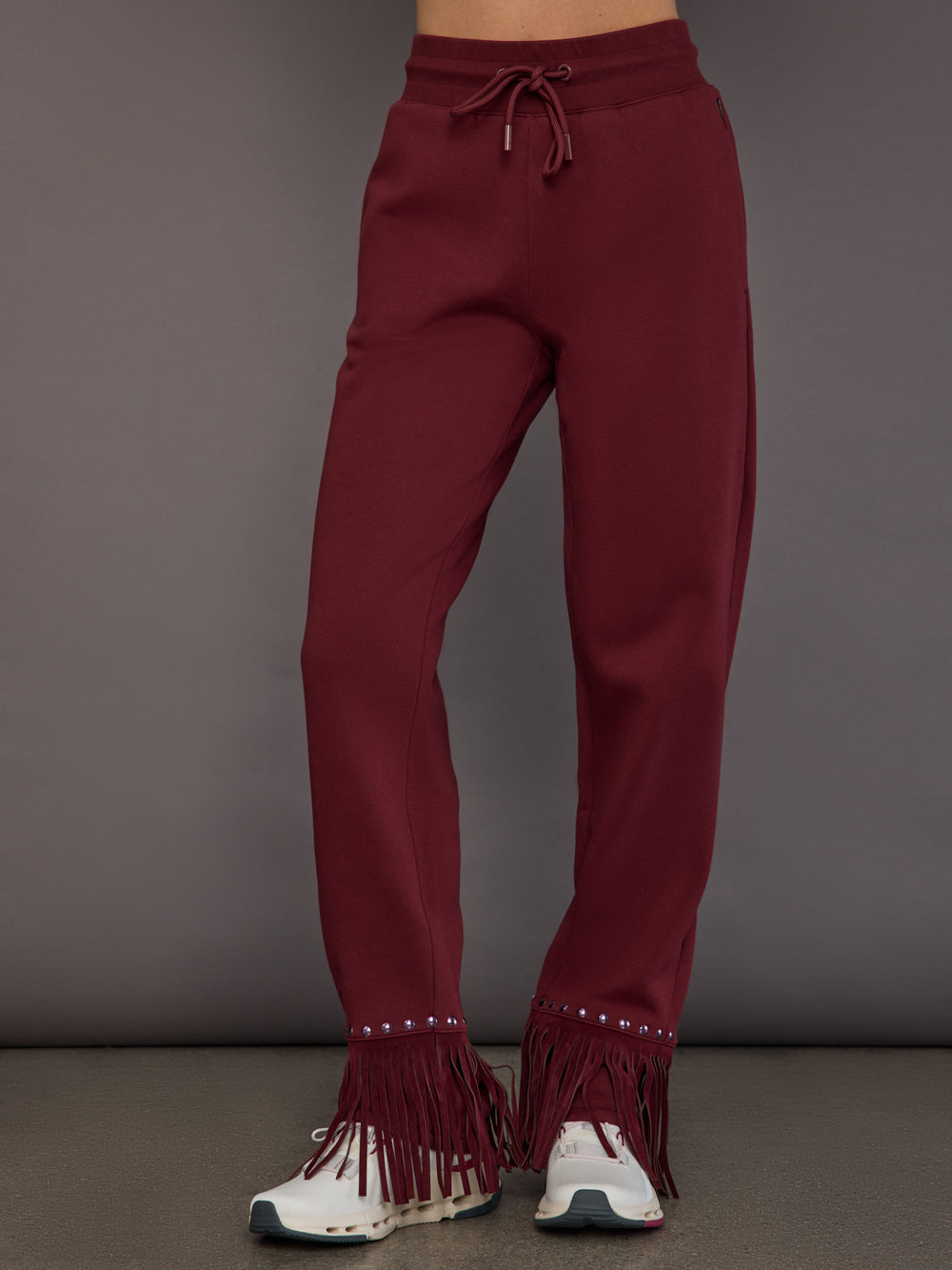 Model wearing wide-leg track pants in vino rosso, front view.