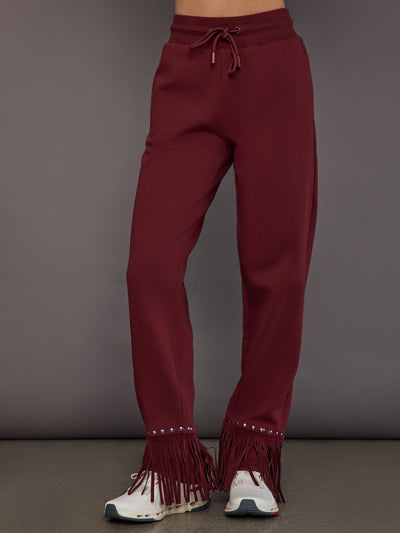 Model wearing wide-leg track pants in vino rosso, front view.