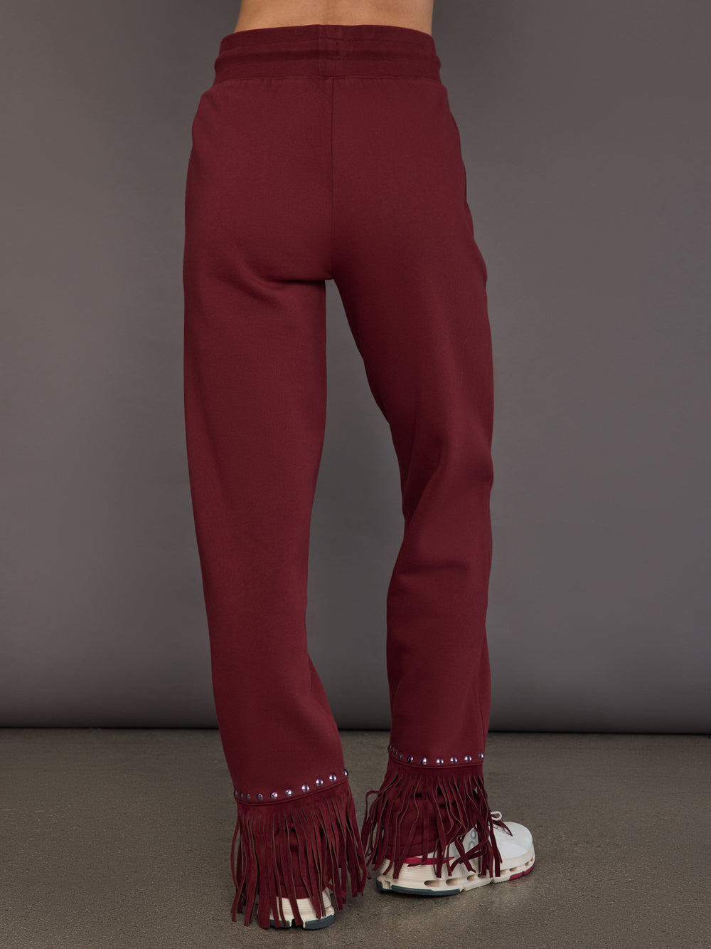 Model wearing vino rosso track pants, back view.