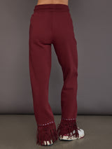 Model wearing vino rosso track pants, back view.
