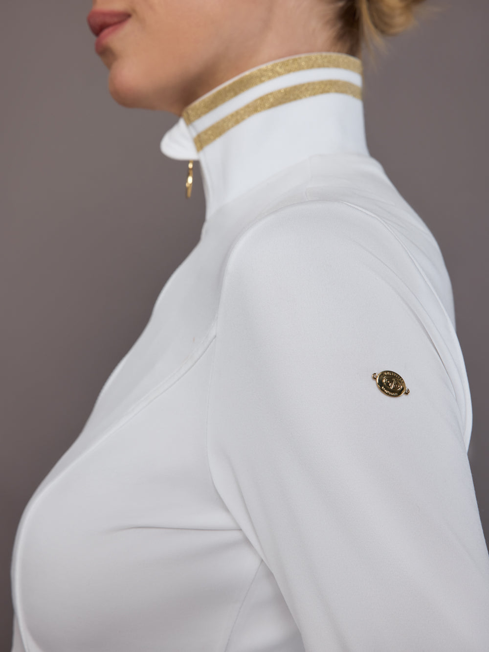 Close-up of sleeve badge and gold accent detail.