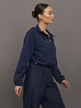 Model wears a navy hooded track jacket.