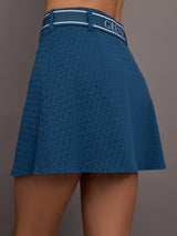 Model is wearing a blue quarter active skirt with built in shorts and pockets