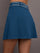 Model is wearing a blue quarter active skirt with built in shorts and pockets