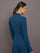 Model is wearing a blue quarter zip long sleeve fitted top and a matching blue sport skirt