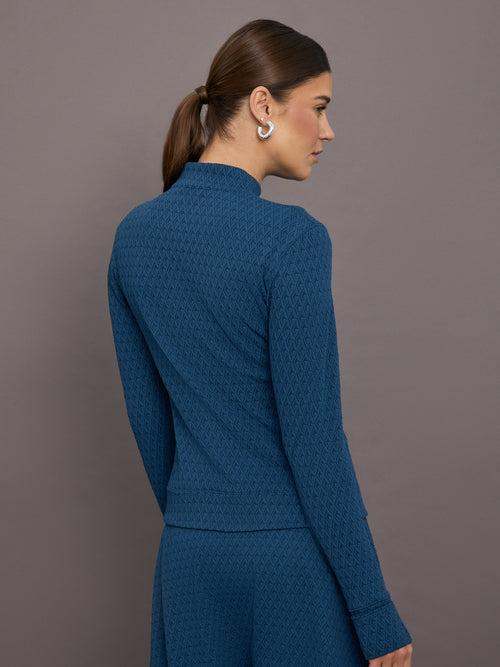 Model is wearing a blue quarter zip long sleeve fitted top and a matching blue sport skirt