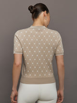 Woman wearing a beige patterned top against a brown background