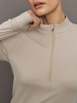Beige long-sleeve top with a quarter zip on a neutral background