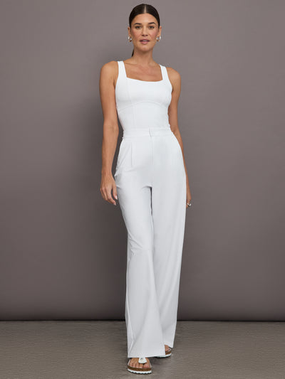 Model is wearing a white cross back fitted tank and white pants