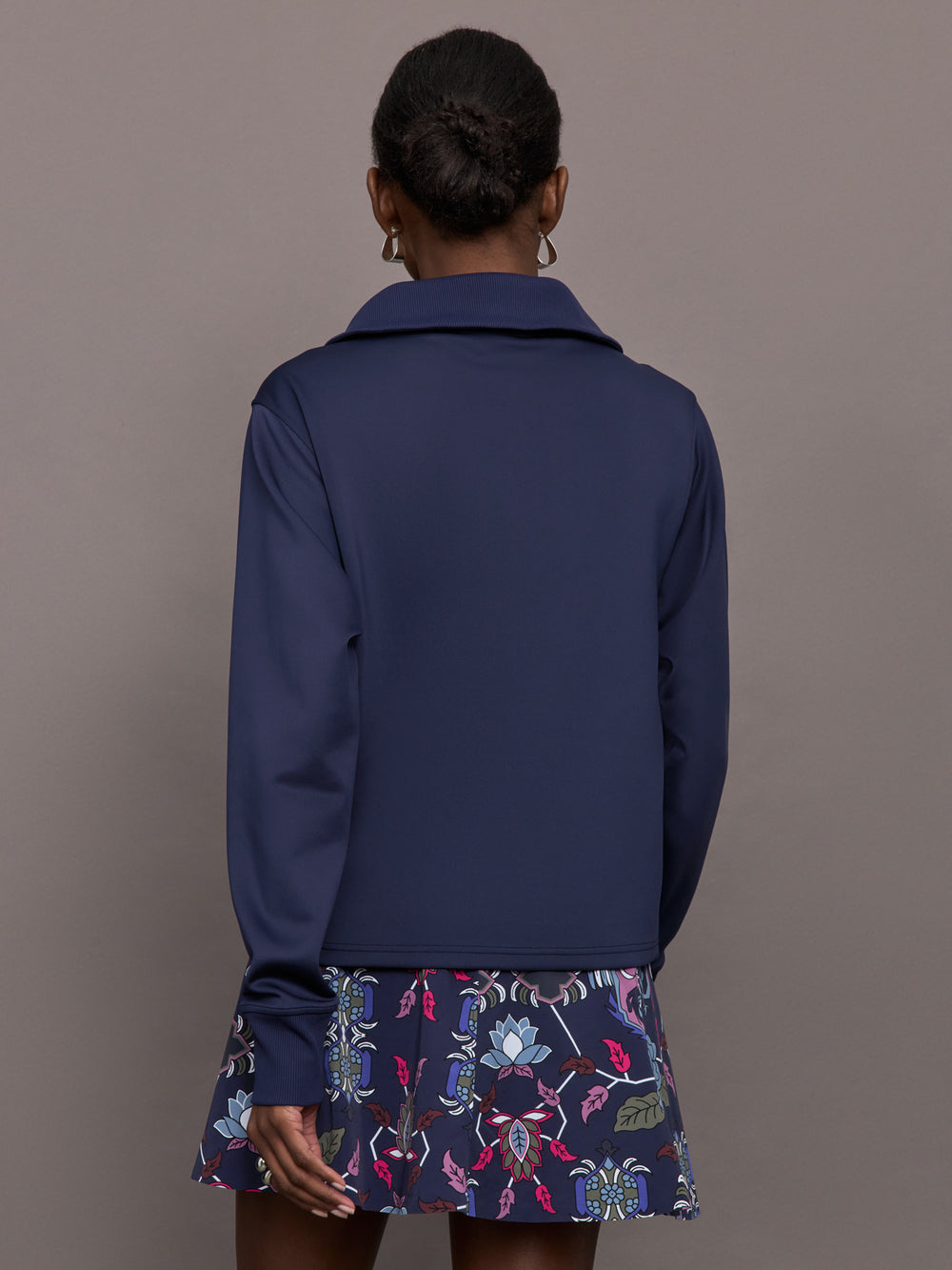 Model wearing a blue quarter zip sweatshirt