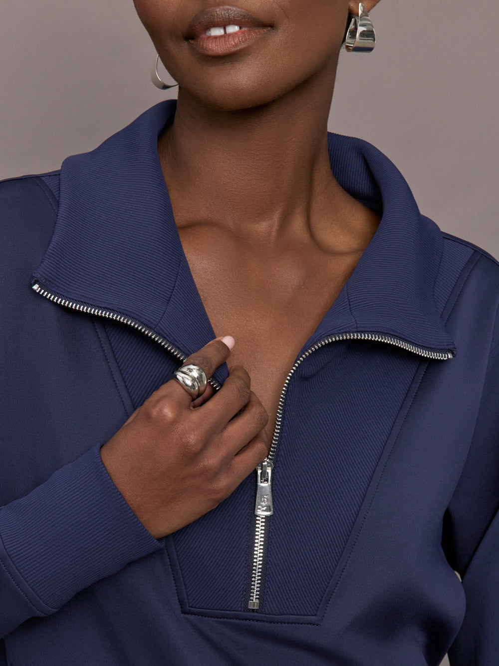 Model wearing a blue quarter zip sweatshirt