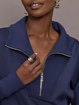 Model wearing a blue quarter zip sweatshirt