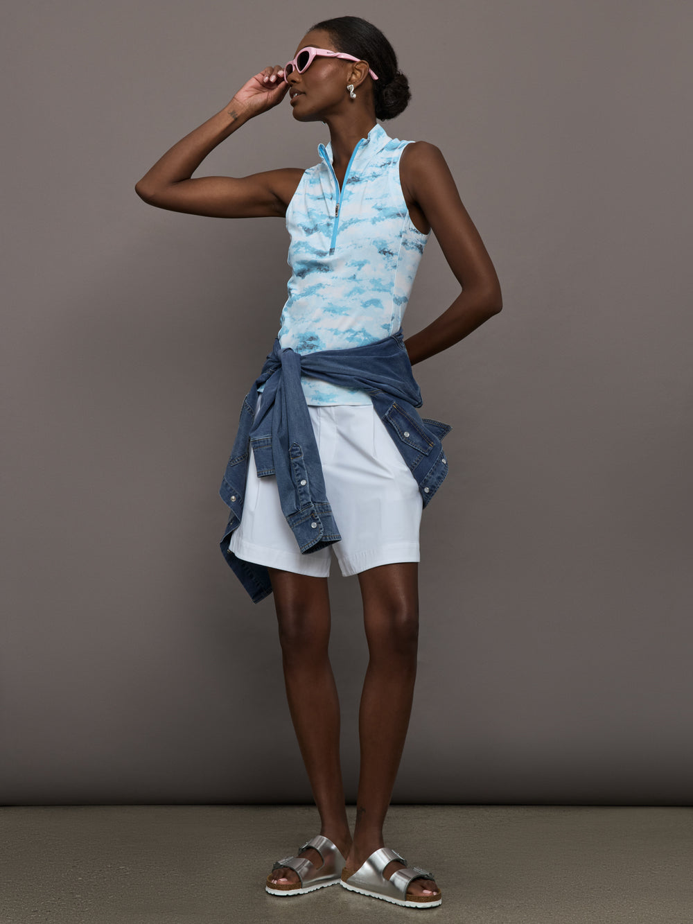 Model wears sleeveless quarter-zip top with a slim, athletic fit and a high collar.