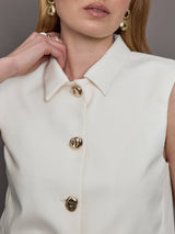 Model wears a white collared tank with chunky gold buttons and symmetrical pockets below the waist.