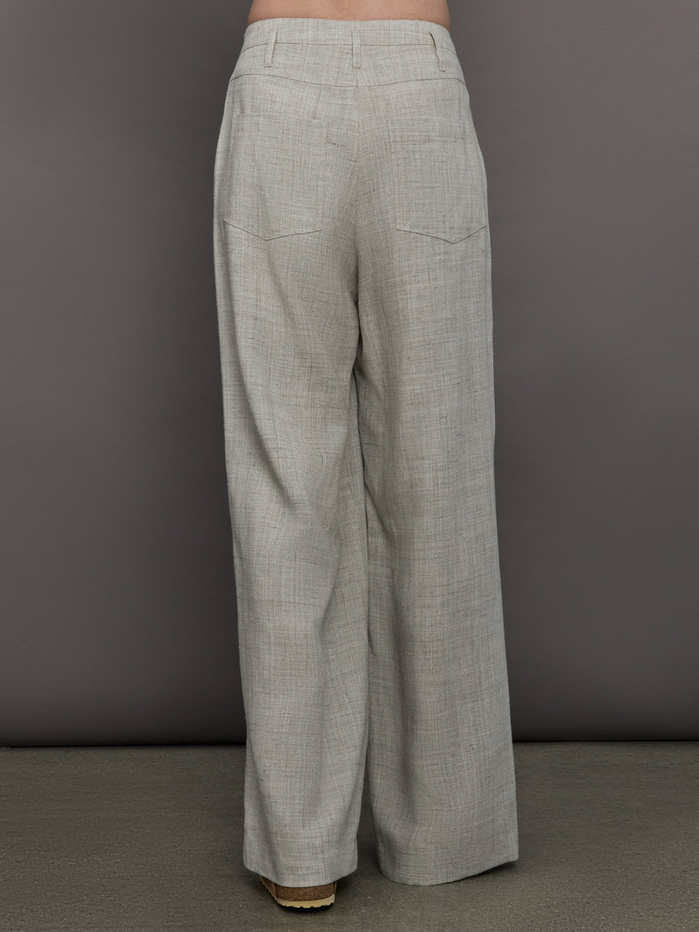 Model wears a pair of gray/taupe oversized wide leg woven work trousers.