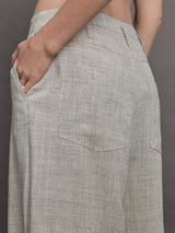 Model wears a pair of gray/taupe oversized wide leg woven work trousers.