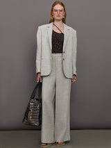 Model wears a pair of gray/taupe oversized wide leg woven work trousers.