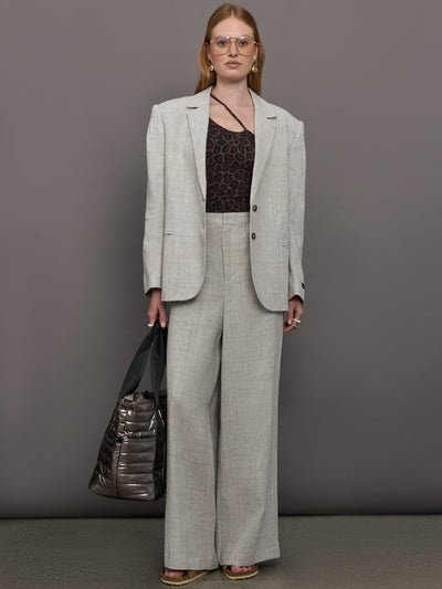 Model wears a gray/taupe textured oversized blazer with single button closure.
