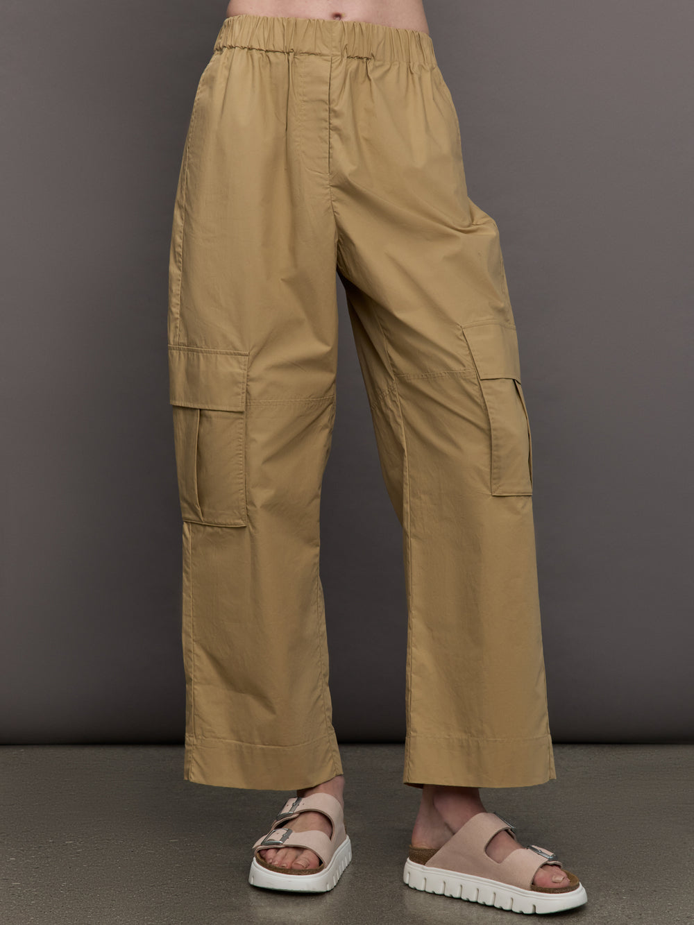 Model wears a pair of mid rise khaki cargo wide leg pants.