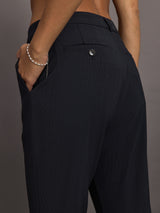 Model wears black capri pants with a mid-rise.