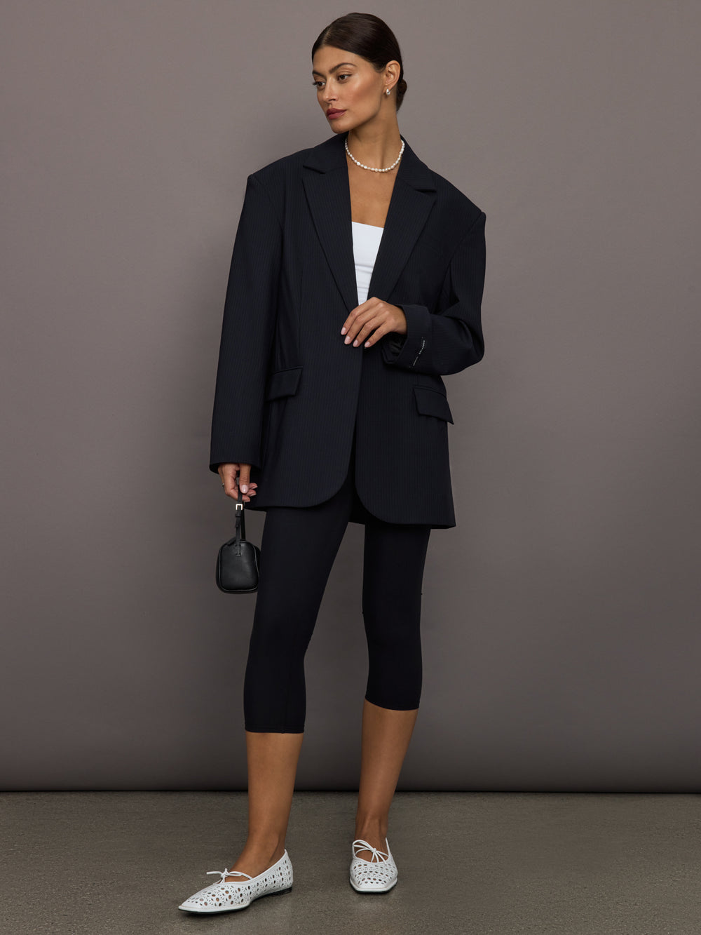Model wearing a black oversized blazer with pockets.