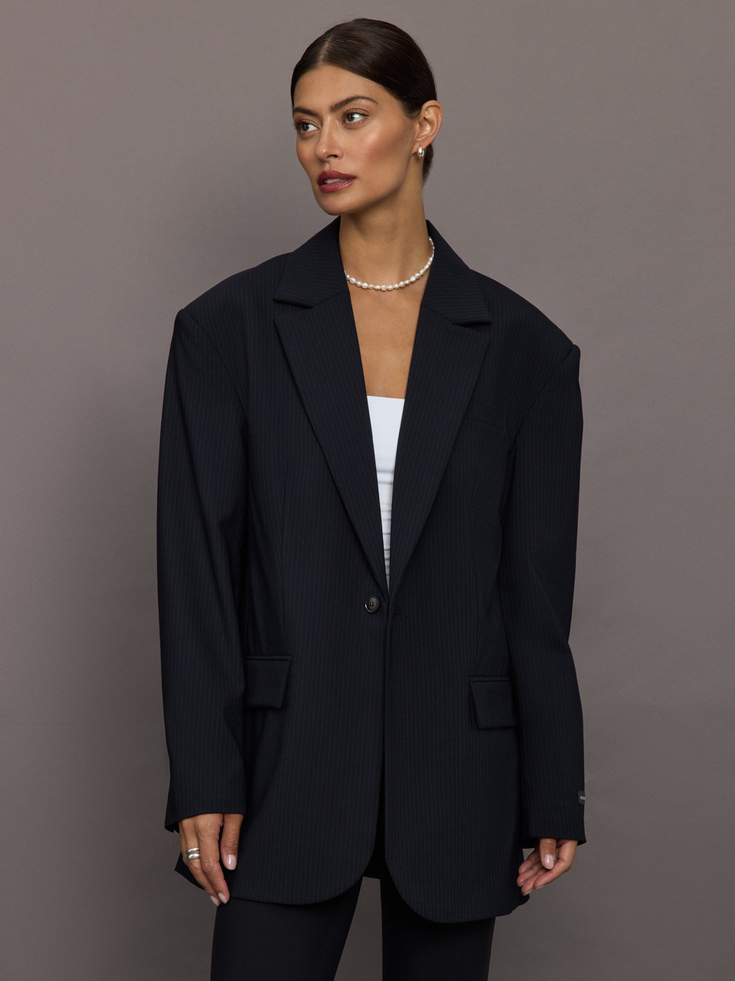 Model wearing a black oversized blazer with pockets.
