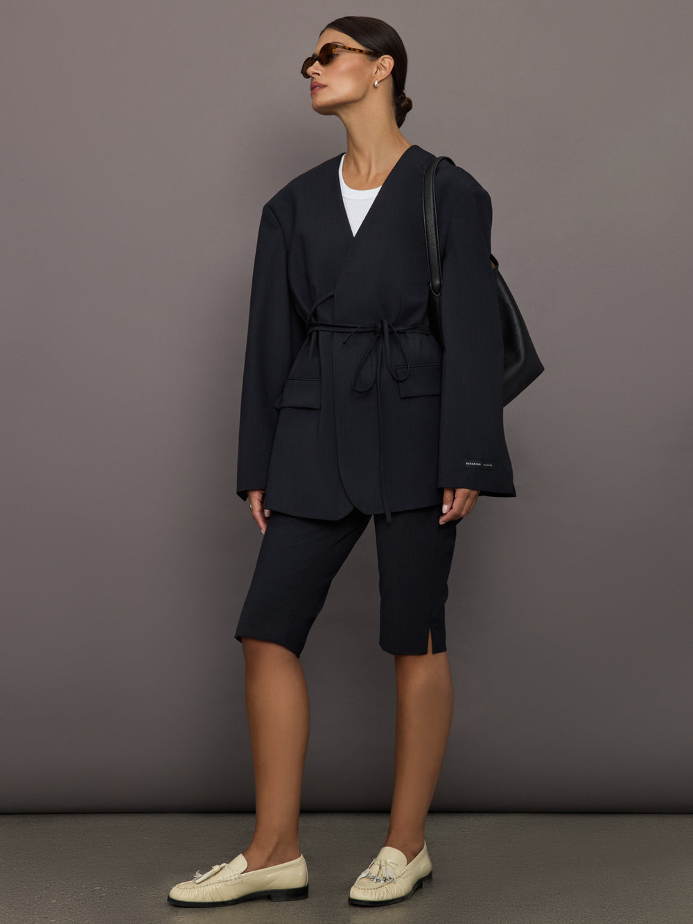 Model wearing a black oversized blazer with pockets.