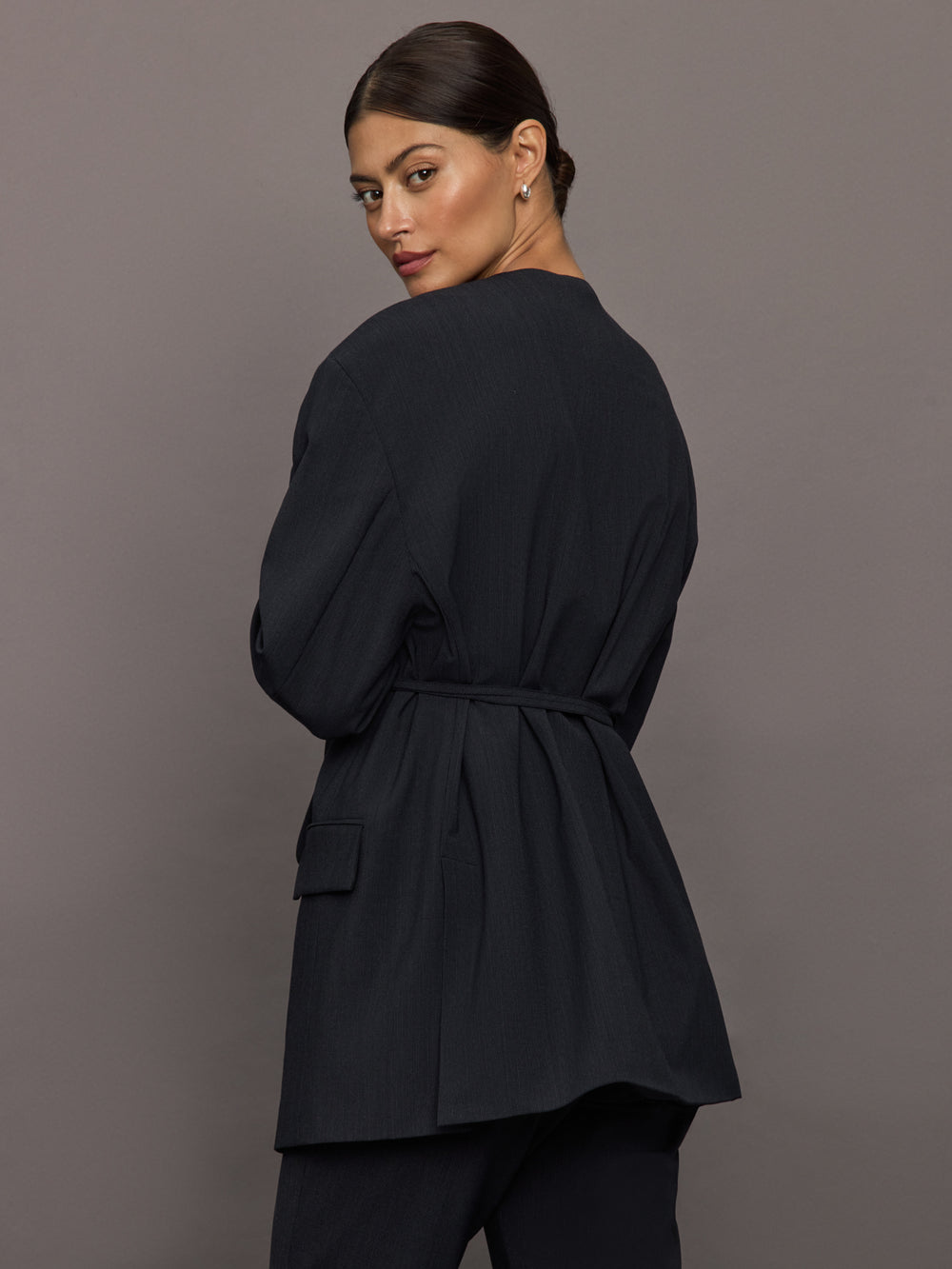 Model wearing a black blazer with a front tie.