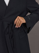 Model wearing a black blazer with a front tie.