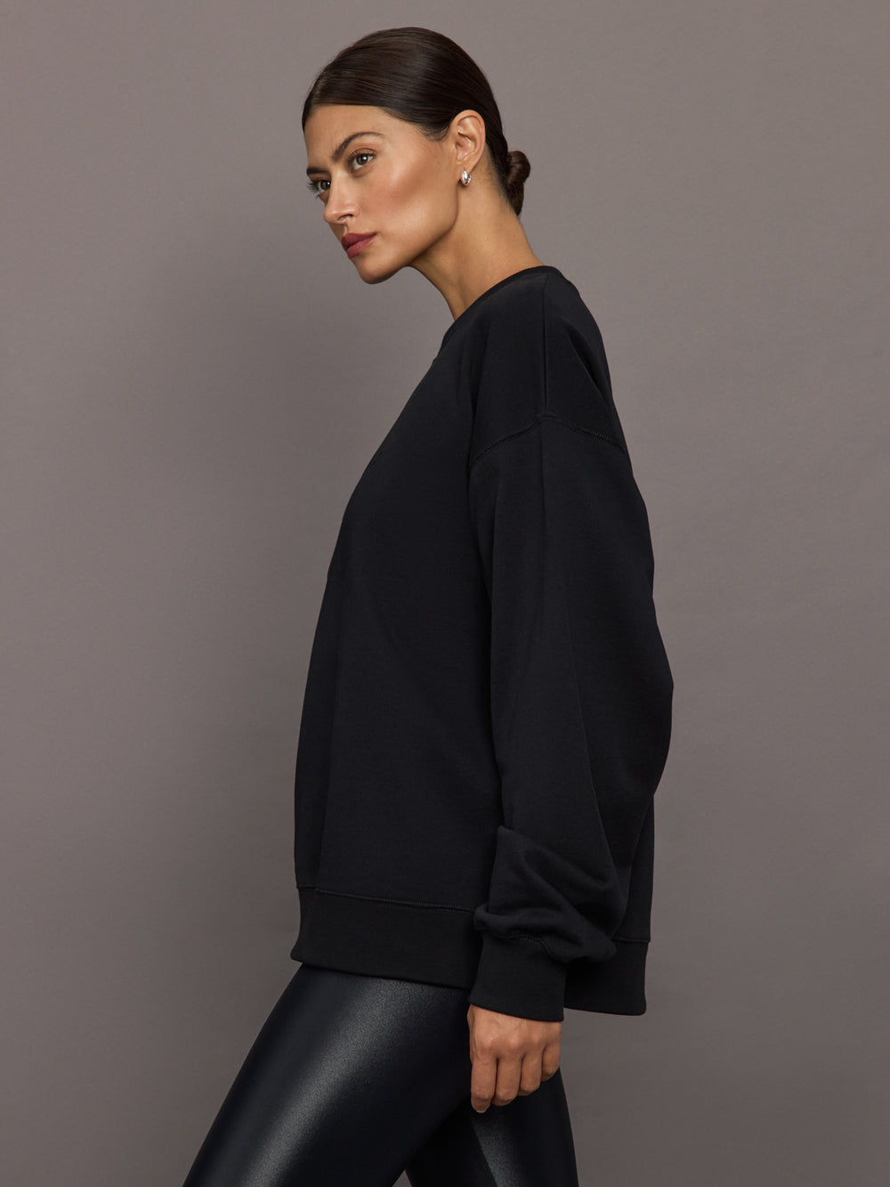 Model wearing a black blouse with 'Hershkind' branding.