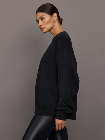 Model wearing a black blouse with 'Hershkind' branding.