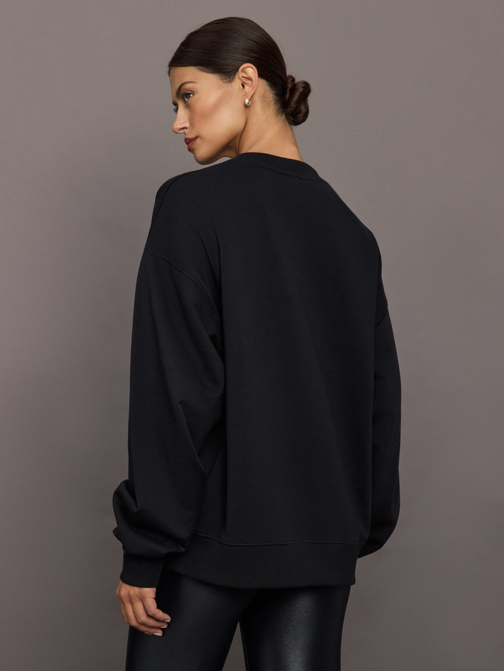 Model wearing a black blouse with 'Hershkind' branding.