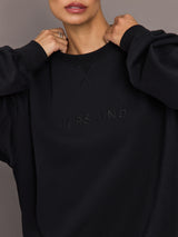Model wearing a black blouse with 'Hershkind' branding.