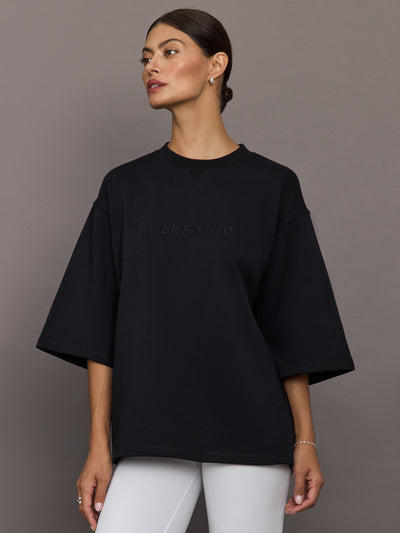 Model wearing a black oversized t-shirt with 'Herskind' text.