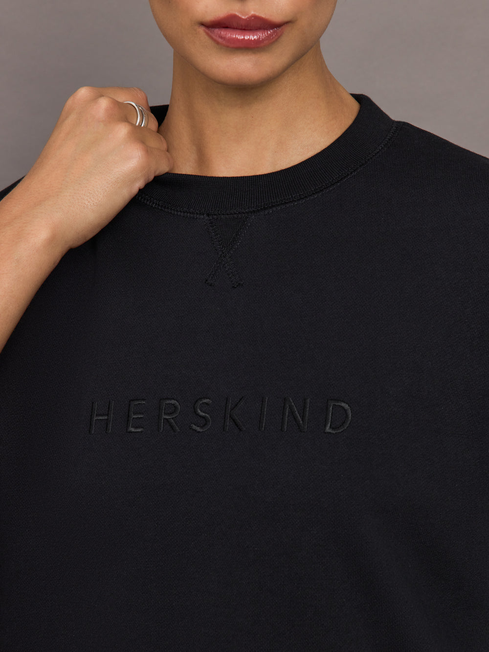 Model wearing a black oversized t-shirt with 'Herskind' text.