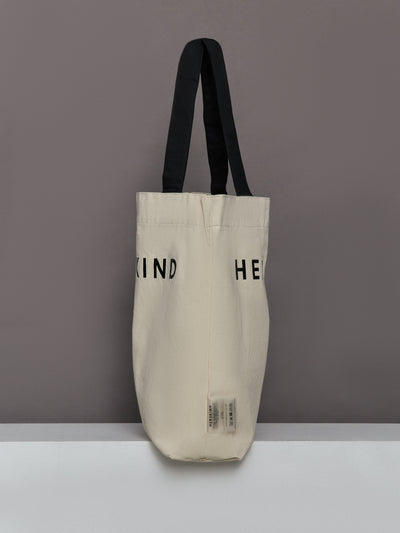 Beige tote bag with black text and handles on a gray background