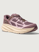 Pink running shoe with a white sole on a light gray background