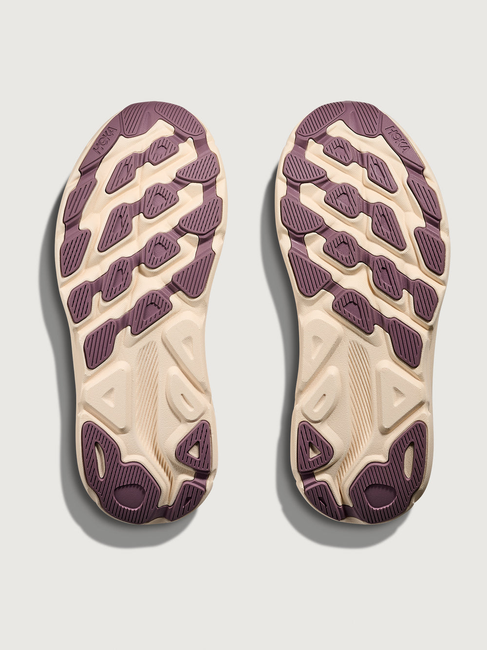 Top view of a pair of shoes with purple soles on a light gray background
