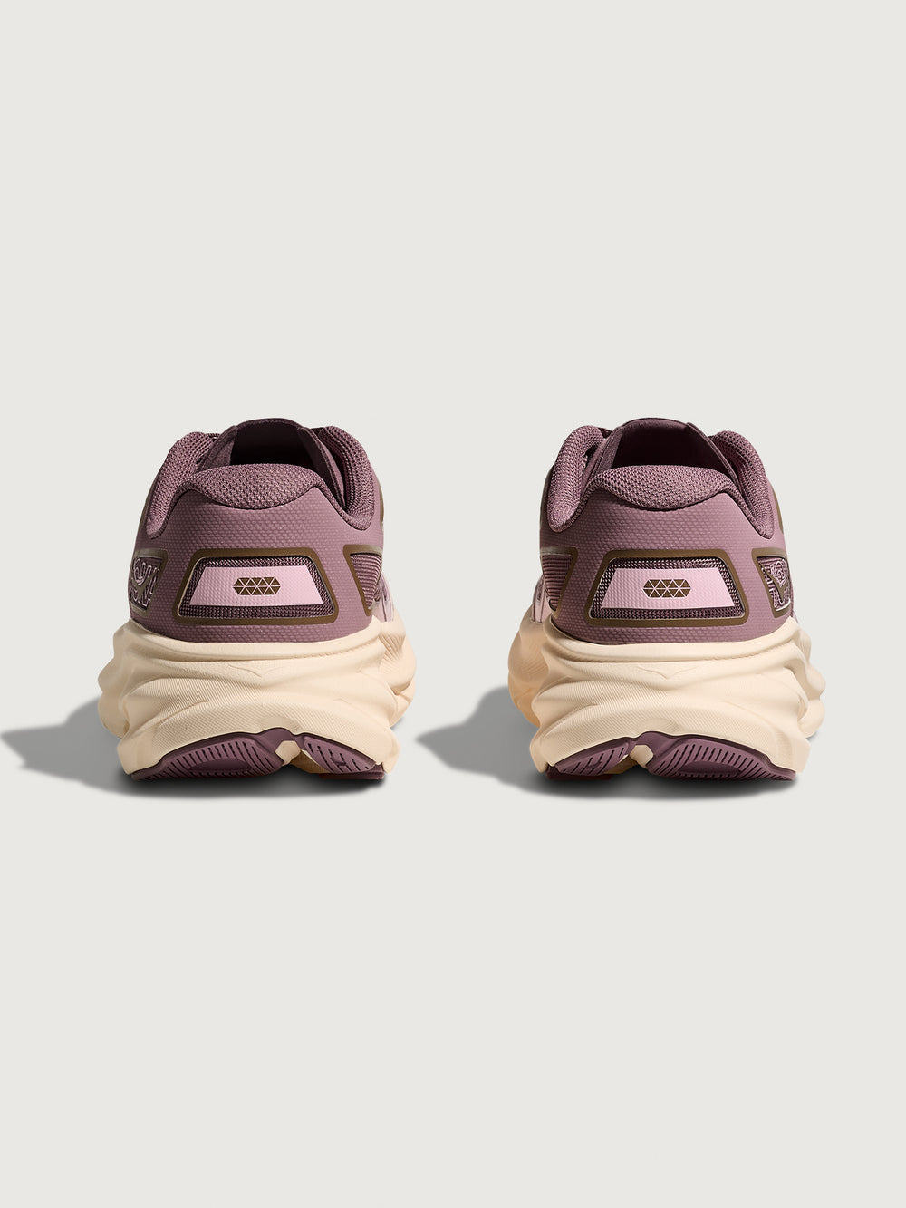 Pair of maroon sneakers with beige soles on a light gray background