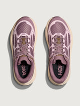Pair of pink running shoes with beige soles on a light gray background