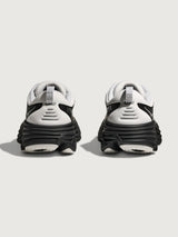 Pair of white and black sneakers on a light gray background