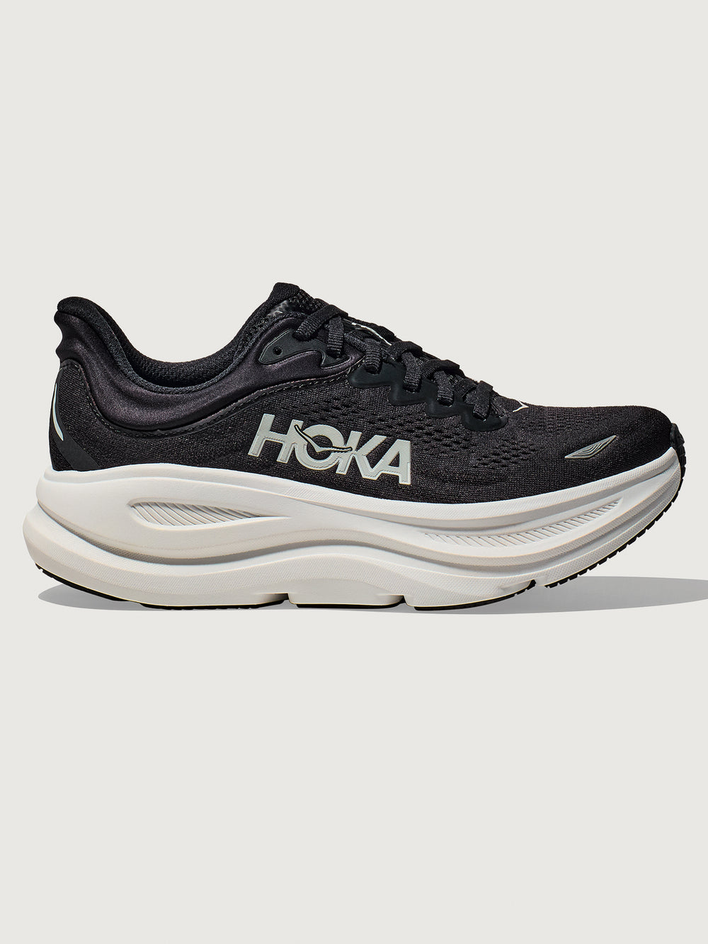 Black running shoe with white sole on a light gray background