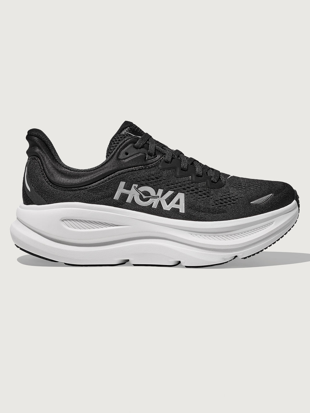 Black running shoe with white sole on a light gray background