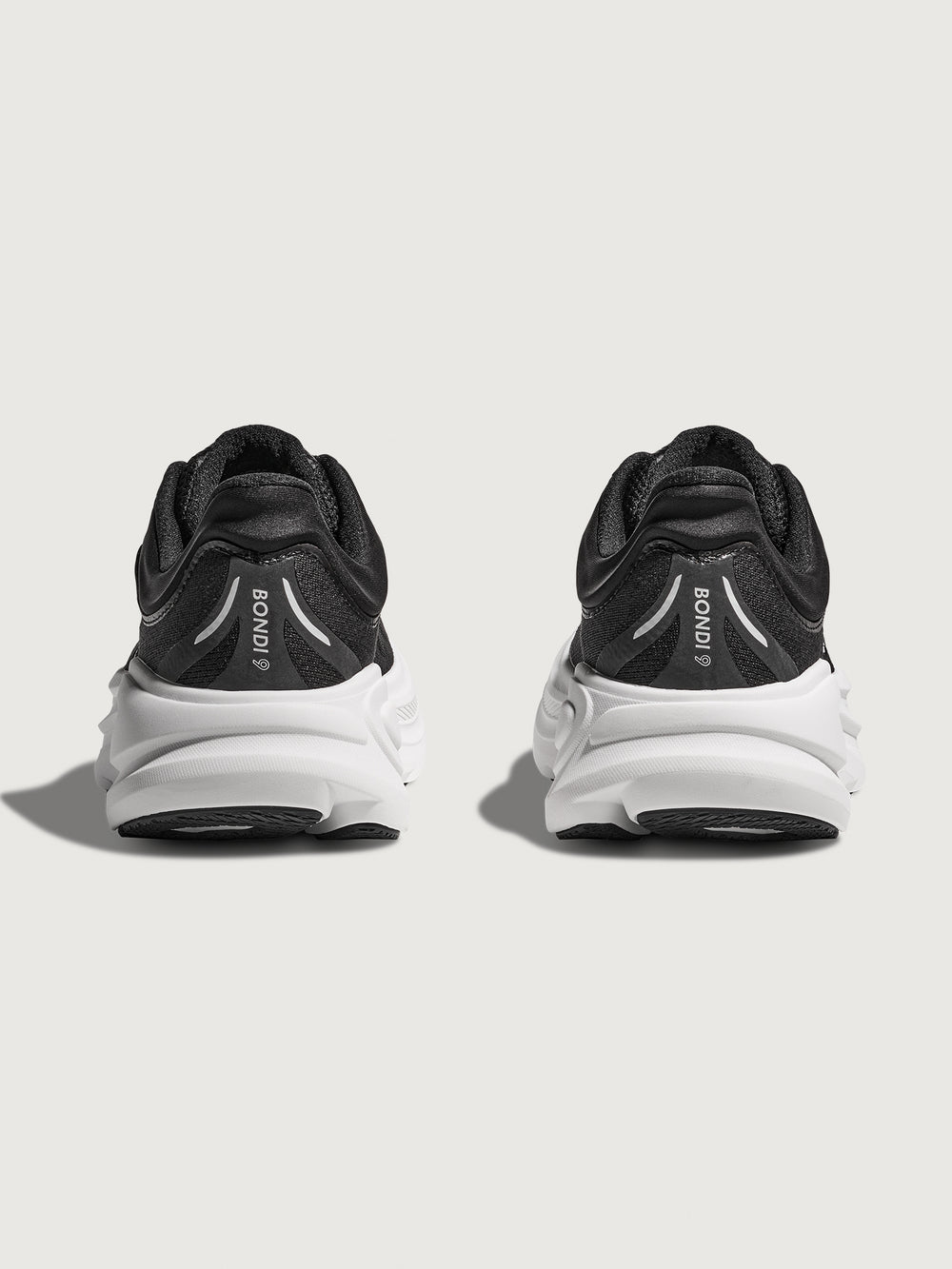 Black running shoe with white sole on a light gray background