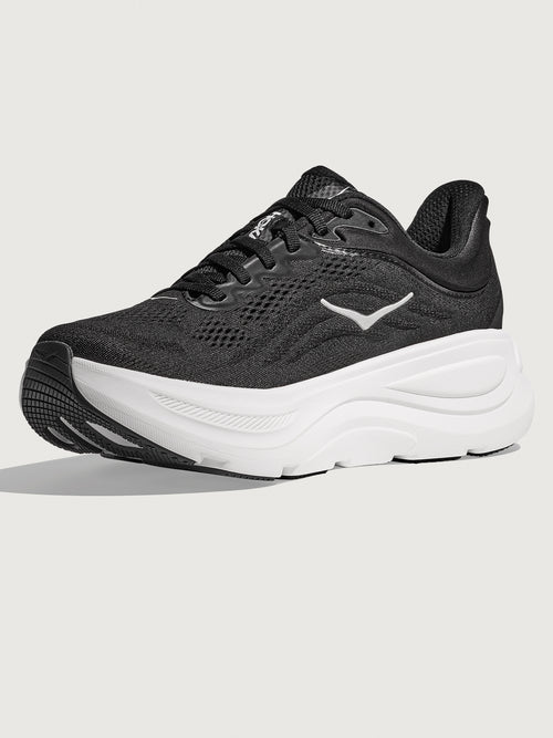 Black running shoe with white sole on a light gray background