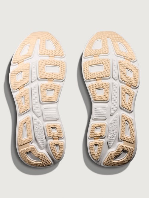 A pair of HOKA running shoes with black and rose gold color scheme.