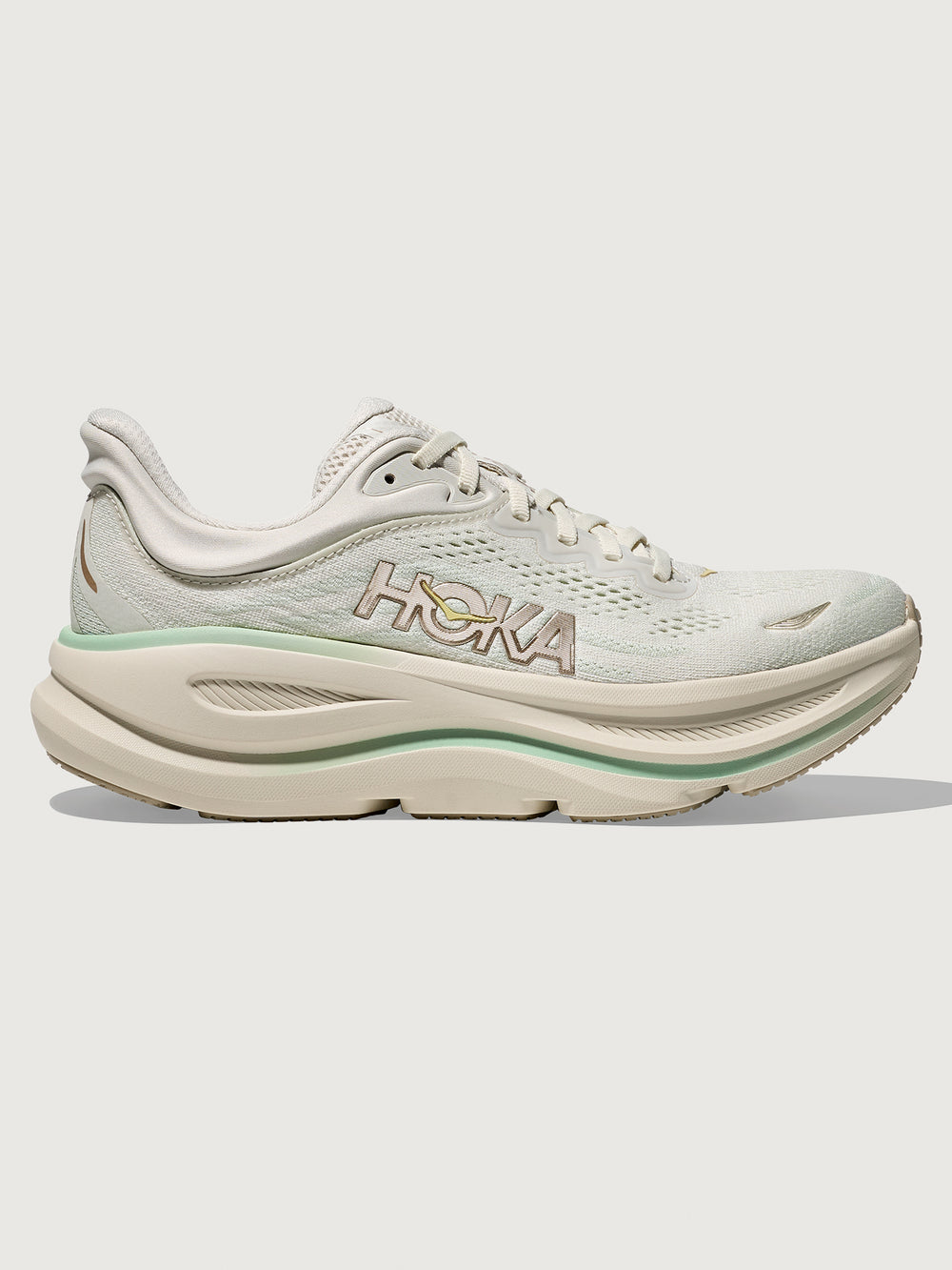 Chunky soled white Hoka running shoe with pastel green trim. 